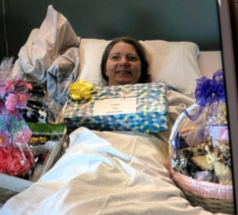 Marianne smiling in hospital bed with presents